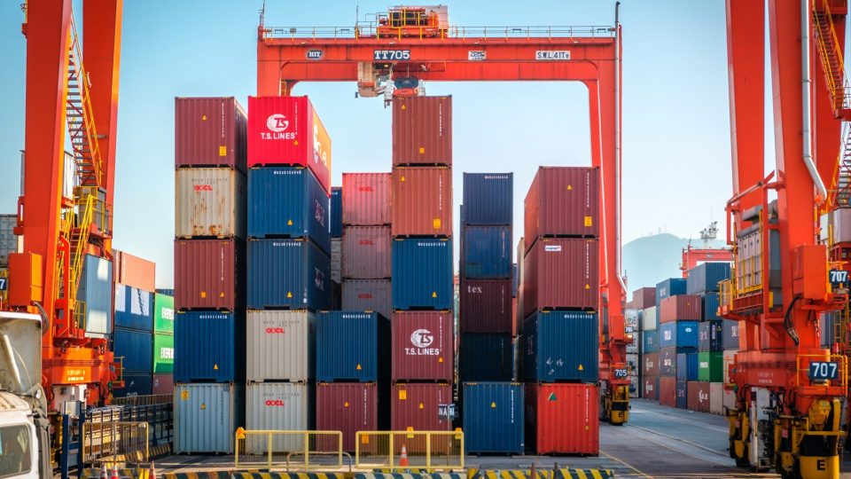 Staplade fraktcontainers i lasthamn för båttransport